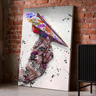 Tableau Street Art Avion en Papier sur toile, posé au sol contre un mur de briques rouges