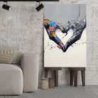 Tableau Street Art Cœur Créatif sur toile, posé sur des tabourets devant un mur de briques