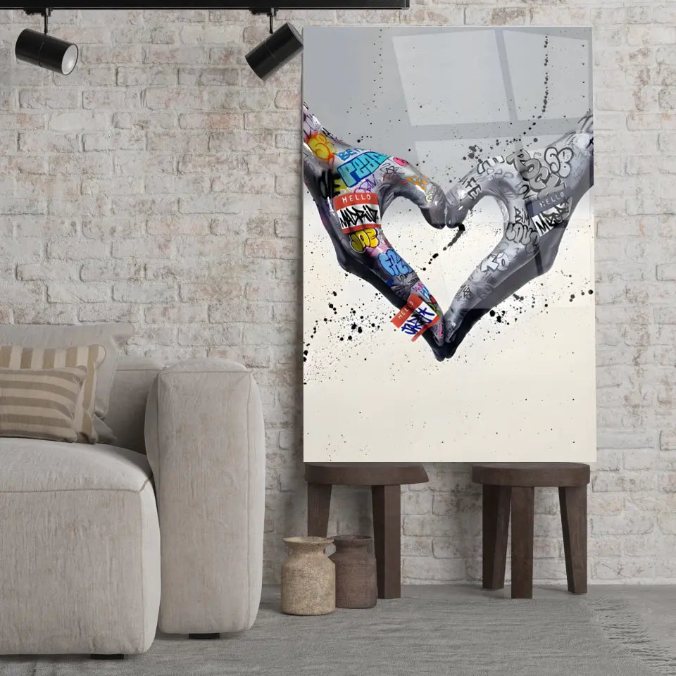 Tableau Street Art Cœur Créatif en verre acrylique, posé sur des tabourets devant un mur de briques