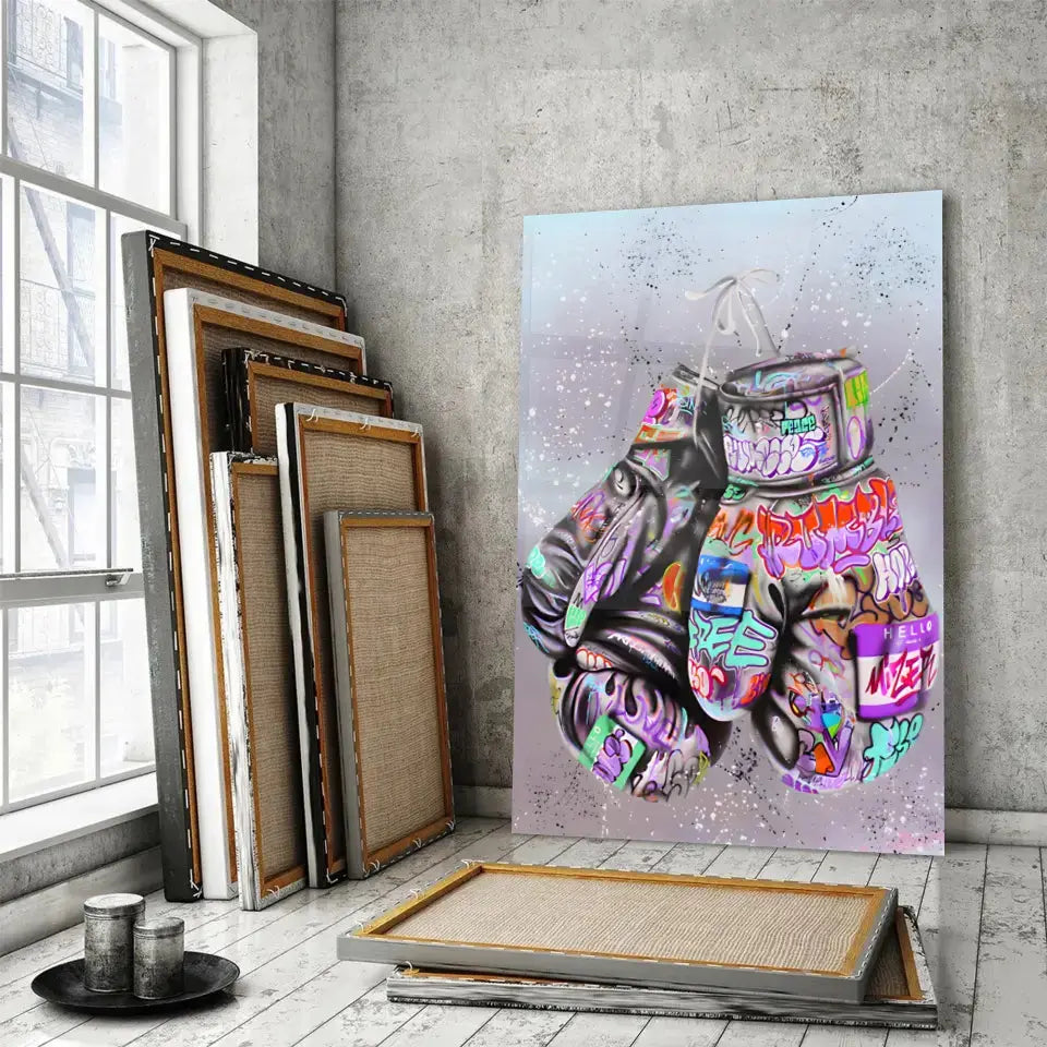 Tableau Street Art Combat Créatif en verre acrylique, posé devant des cadres empilés