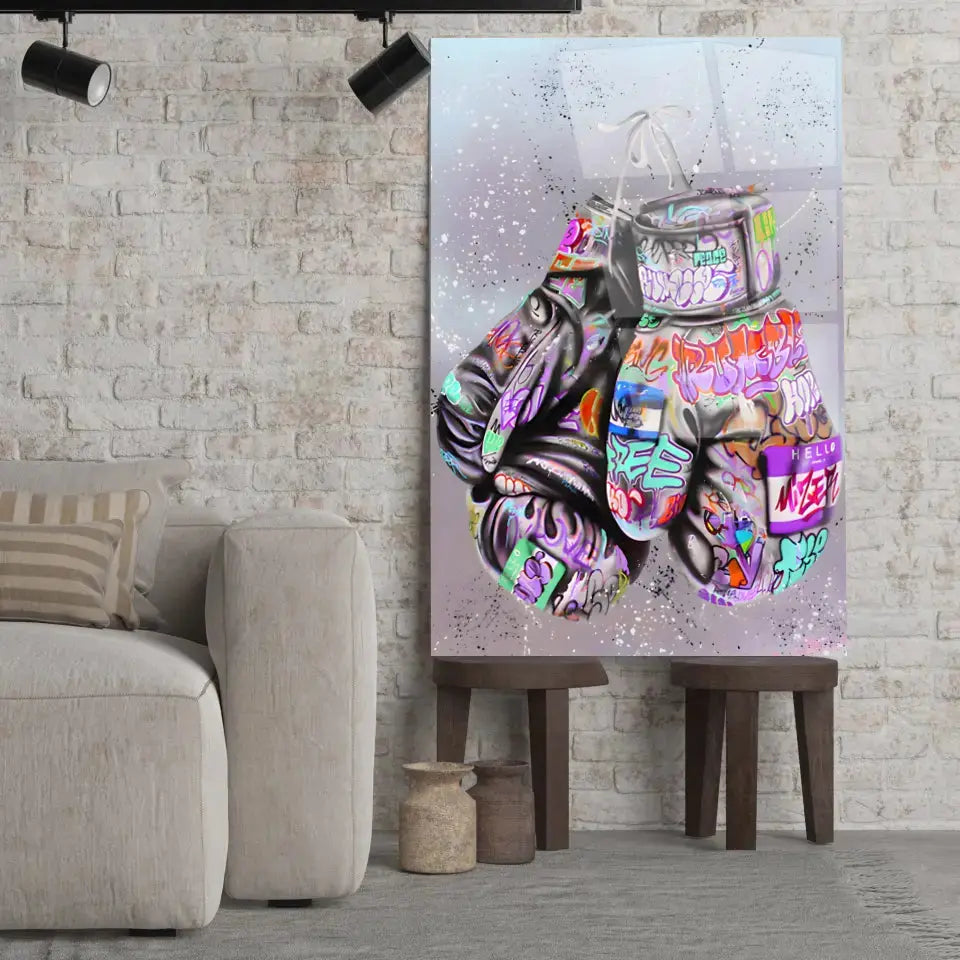 Tableau Street Art Combat Créatif en verre acrylique, posé sur des tabourets devant un mur de briques