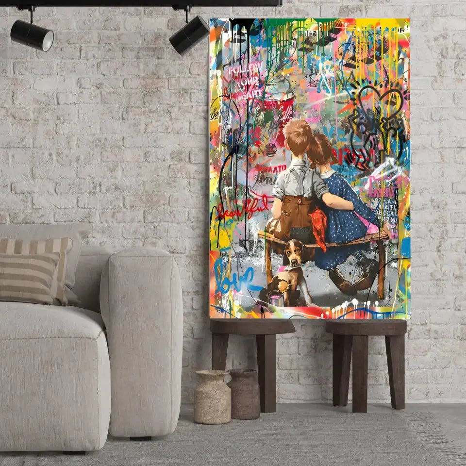 Tableau Street Art Complicité Urbaine sur toile, posé sur des tabourets devant un mur de briques