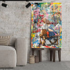 Tableau Street Art Complicité Urbaine en verre acrylique, posé sur des tabourets devant un mur de briques