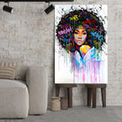 Tableau Street Art Éclat Afro sur toile, posé sur des tabourets devant un mur de briques