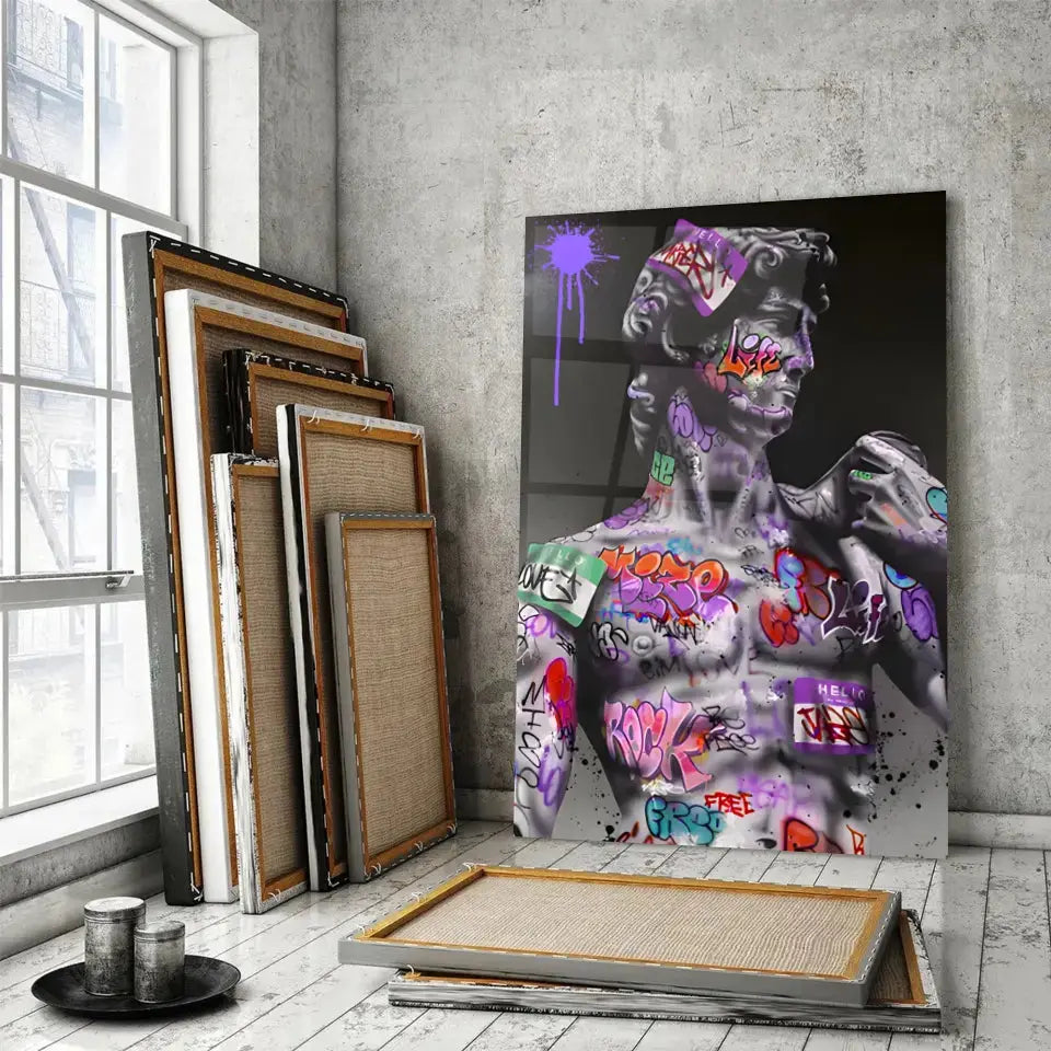 Tableau Street Art Héritage Urbain en verre acrylique, posé devant des cadres empilés
