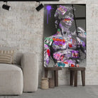 Tableau Street Art Héritage Urbain en verre acrylique, posé sur des tabourets devant un mur de briques
