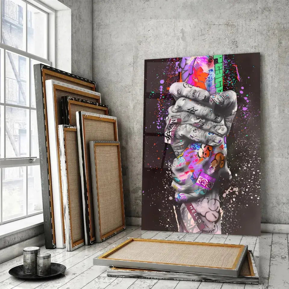 Tableau Street Art Lien Urbain en verre acrylique, posé devant des cadres empilés