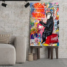 Tableau Street Art Pause Urbaine sur toile, posé sur des tabourets devant un mur de briques