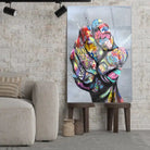 Tableau Street Art Poing de Révolte en verre acrylique, posé sur des tabourets devant un mur de briques