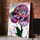 Tableau Street Art Rose Urbaine sur toile, posé au sol contre un mur de briques rouges
