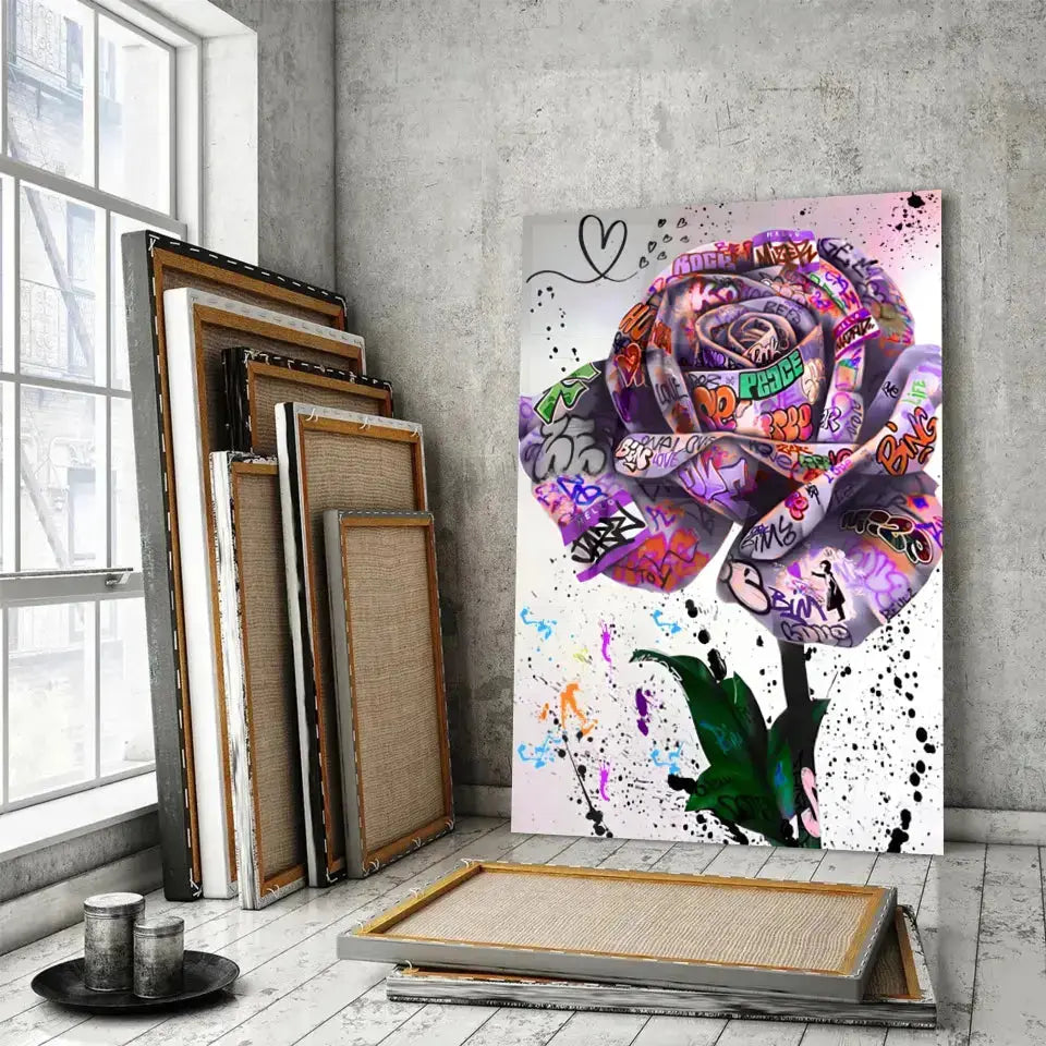 Tableau Street Art Rose Urbaine en verre acrylique, posé devant des cadres empilés