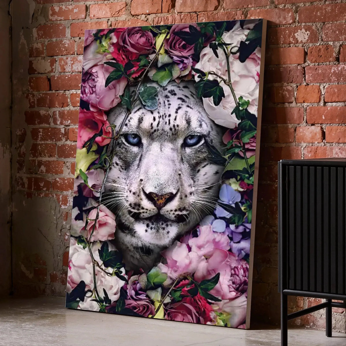 Tableau tigre blanc fleurs sur toile, posé au sol contre un mur de briques rouges