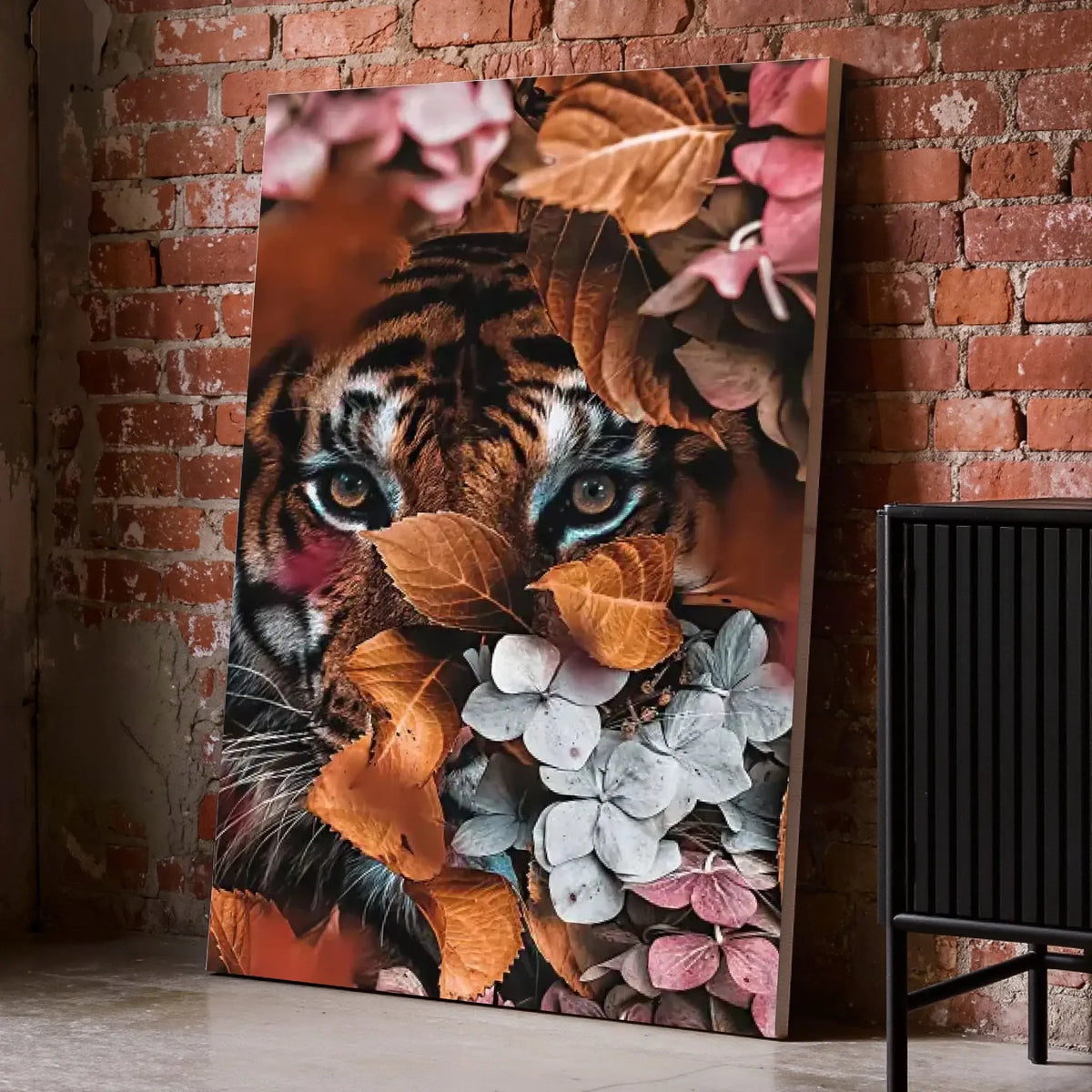 Tableau tigre feuillage sur toile, posé au sol contre un mur de briques rouges