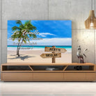Toile prénoms personnalisée plage et cocotiers posée sur un meuble bas, décoration salon