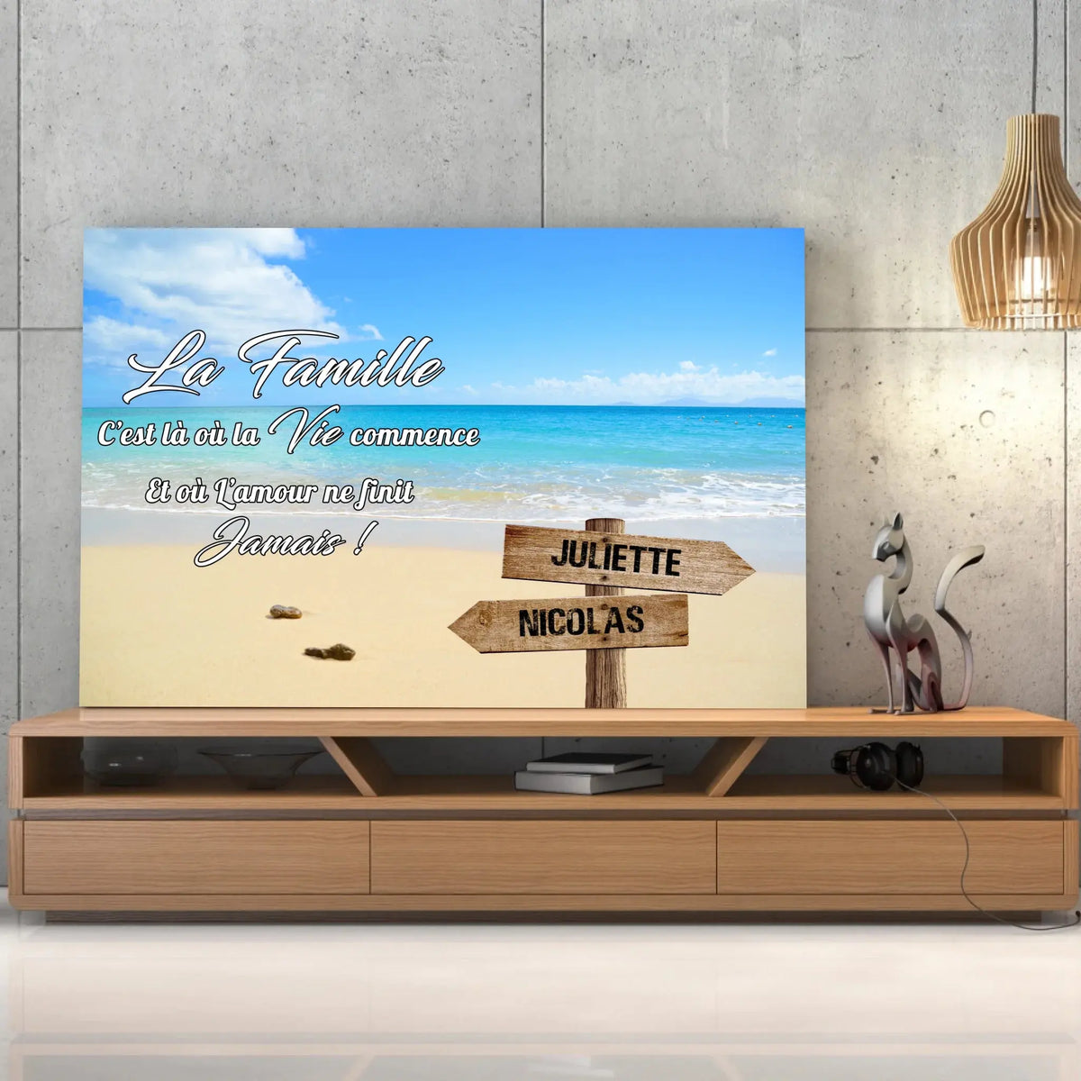 Toile prénoms personnalisée plage et sable fin posée sur un meuble bas, décoration salon