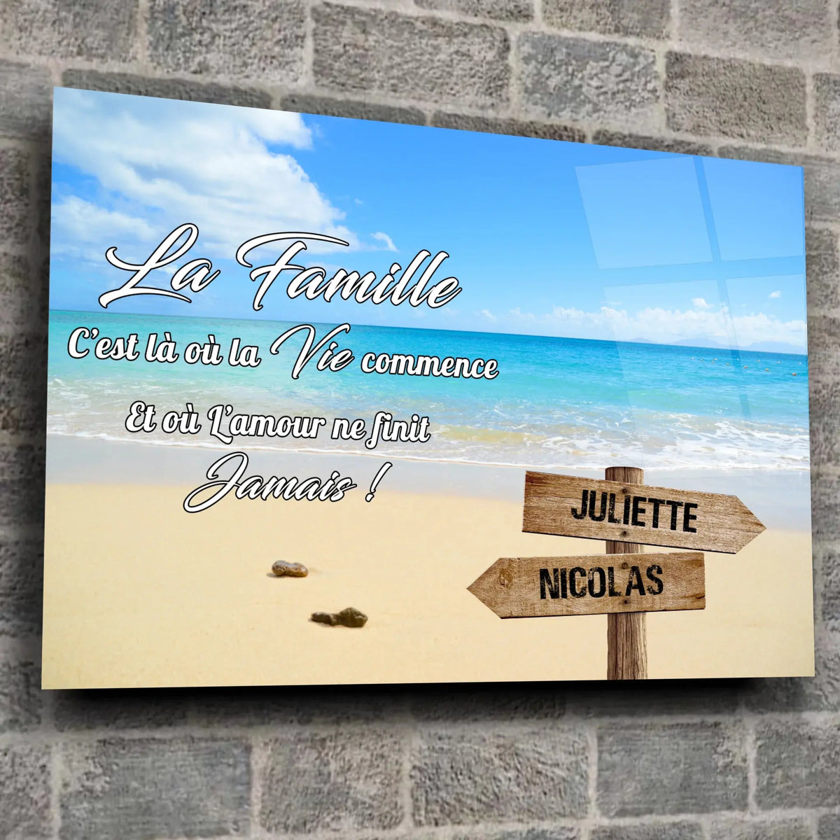 Toile prénoms personnalisée plage et sable fin sur mur de pierre grise, ambiance loft